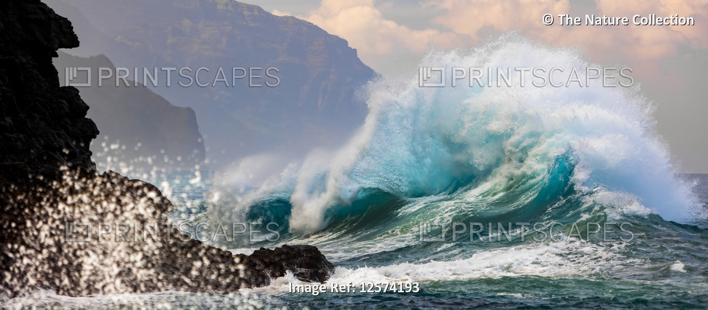 Large ocean wave crashes into rock along the Na Pali Coast; Kauai, Hawaii, ...
