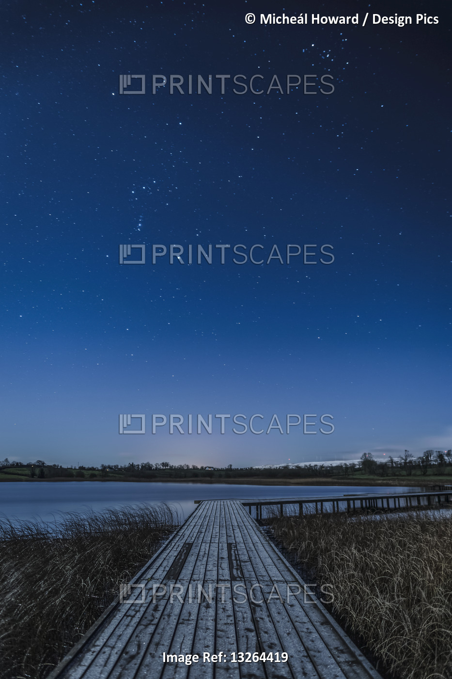 Wooden boardwalk along Lough Erne at night with stars in the sky; County ...