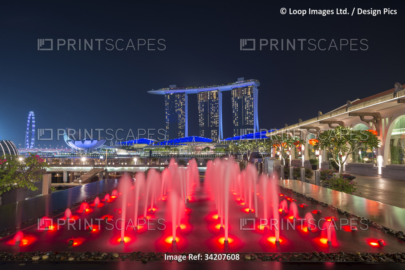 The Marina Bay Sands hotel at night with red water feature.